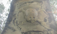 Skulls carved into the stone under the hooded tombs